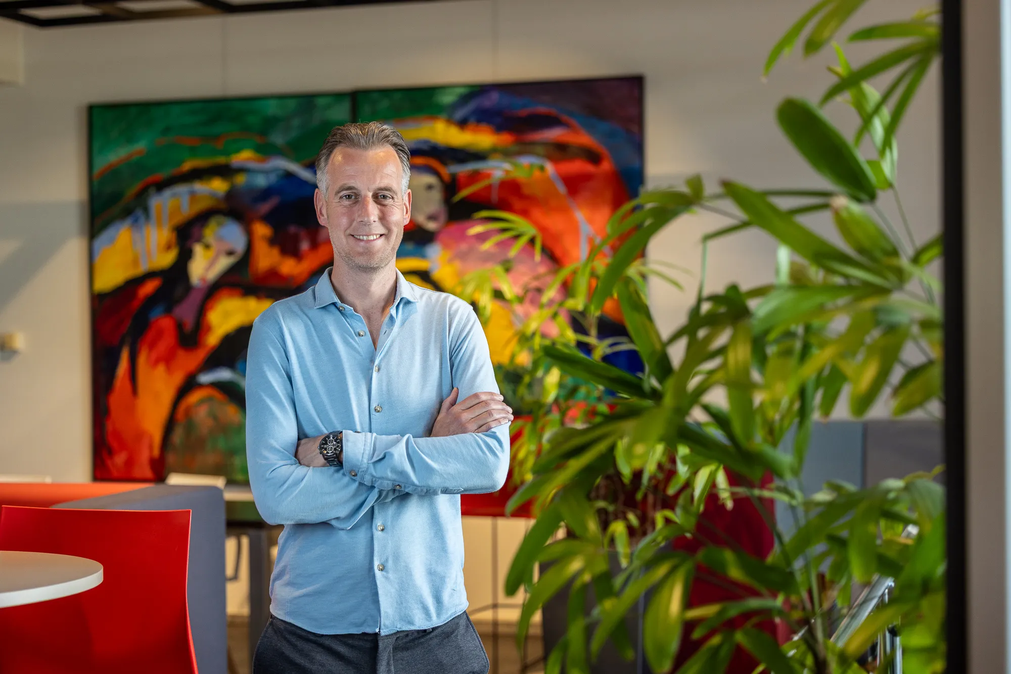 DICTU colllega Olaf Sloot staat voor een rood gevlamd schilderij