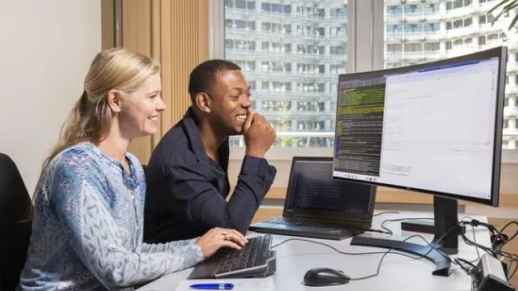 Man en vrouw kijken naar beeldscherm