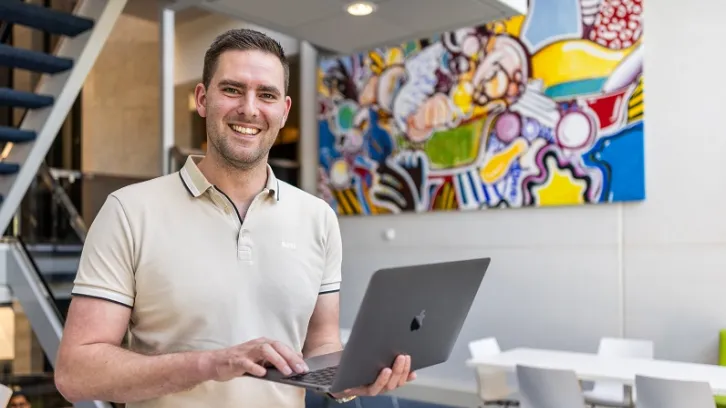 man met laptop op kantoor